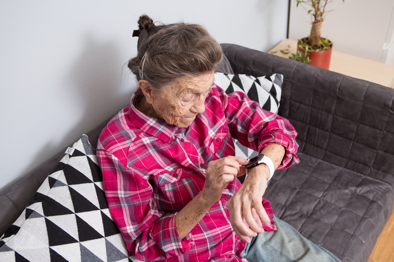 a senior woman using a smartwatch