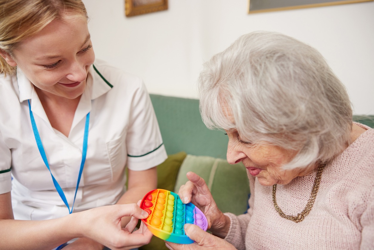 a therapist giving a senior woman a fidget toy