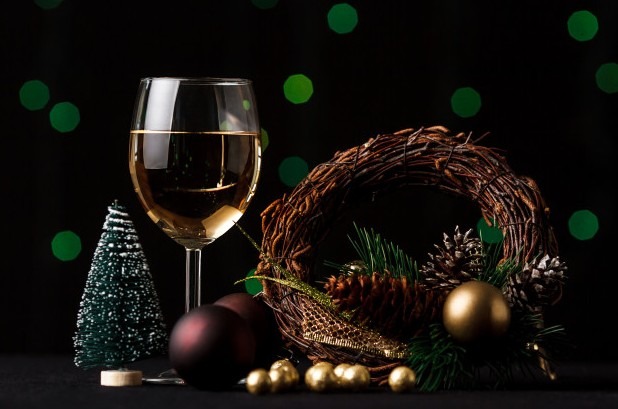 A picture of a wine glass with bells and a wreath as a piece of decoration