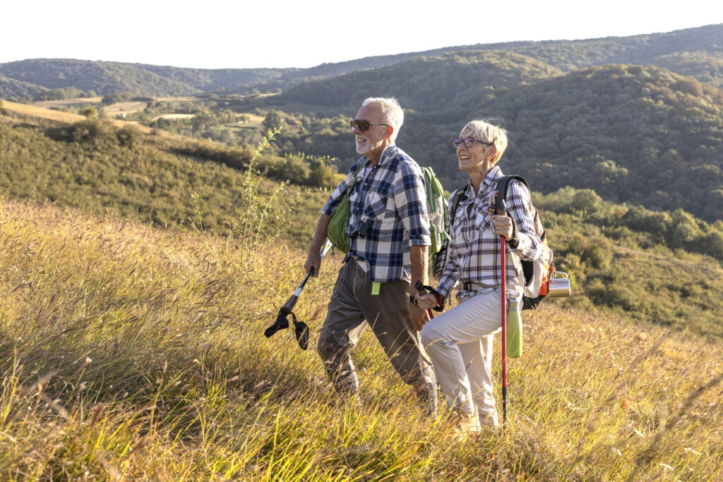Active old woman and man walking at the field and enjoy