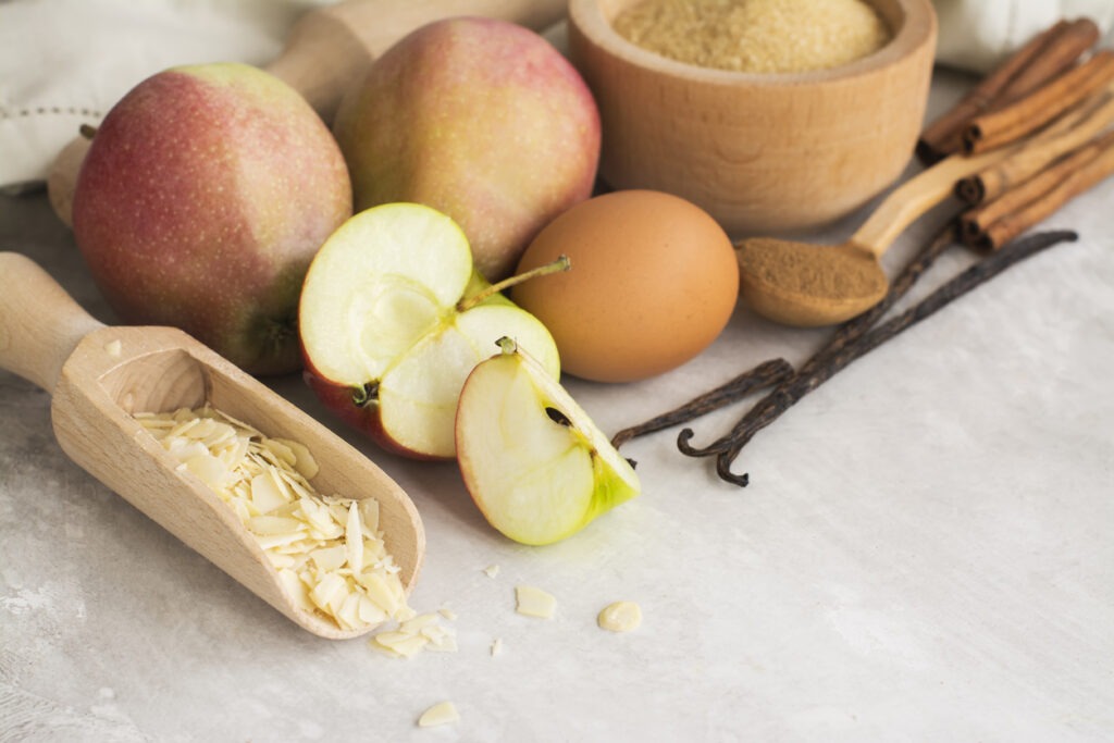 Apple pie or muffin ingredients over stone table. Cooking or baking concept