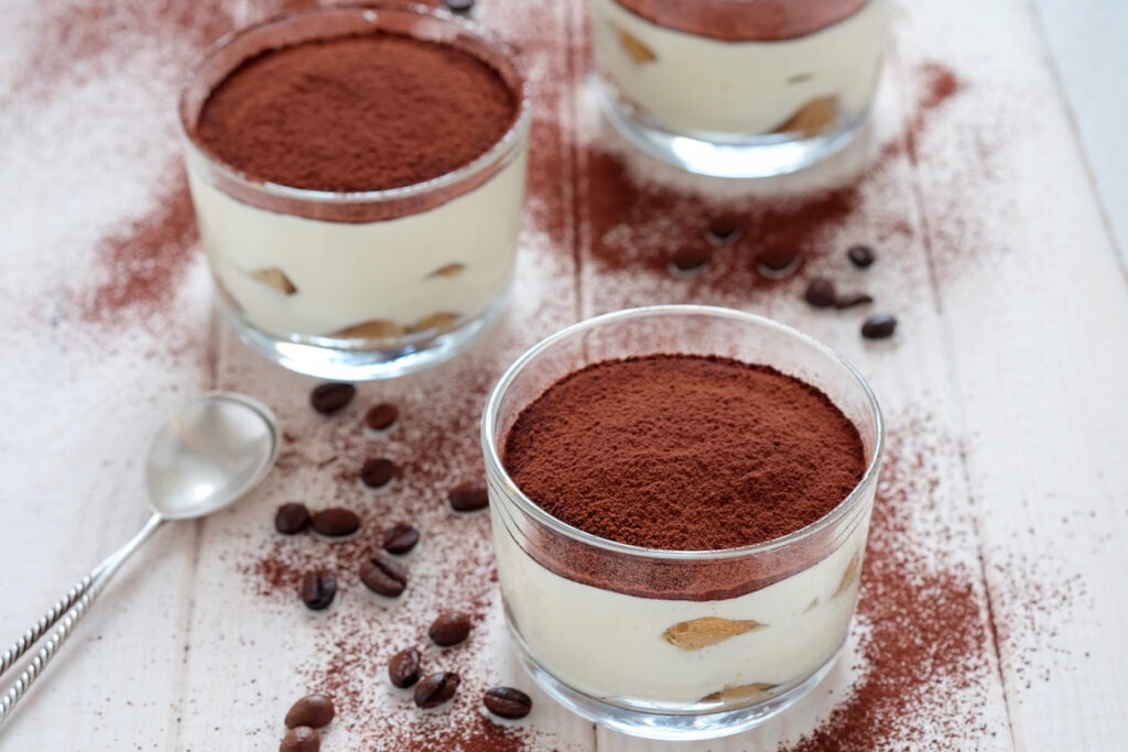 Three portions of traditional Italian dessert tiramisu on the wooden table