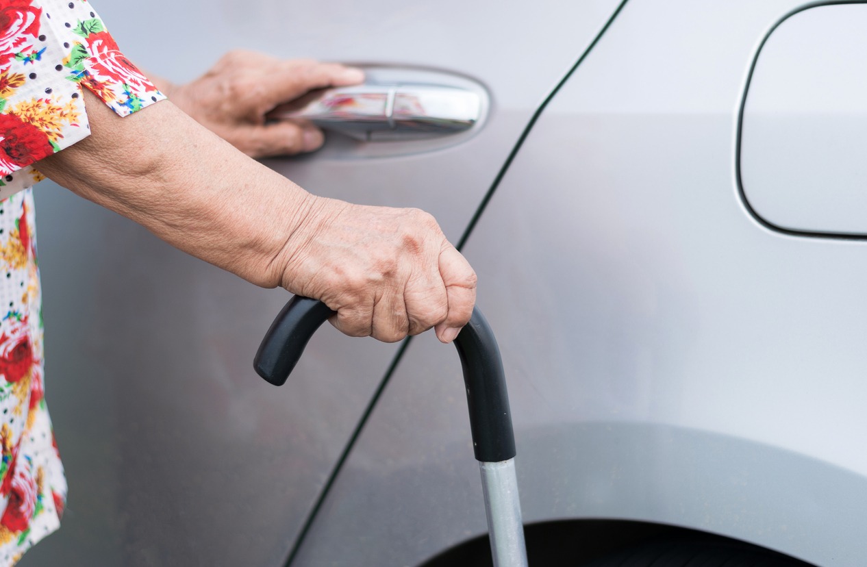 elderly woman opening a car door