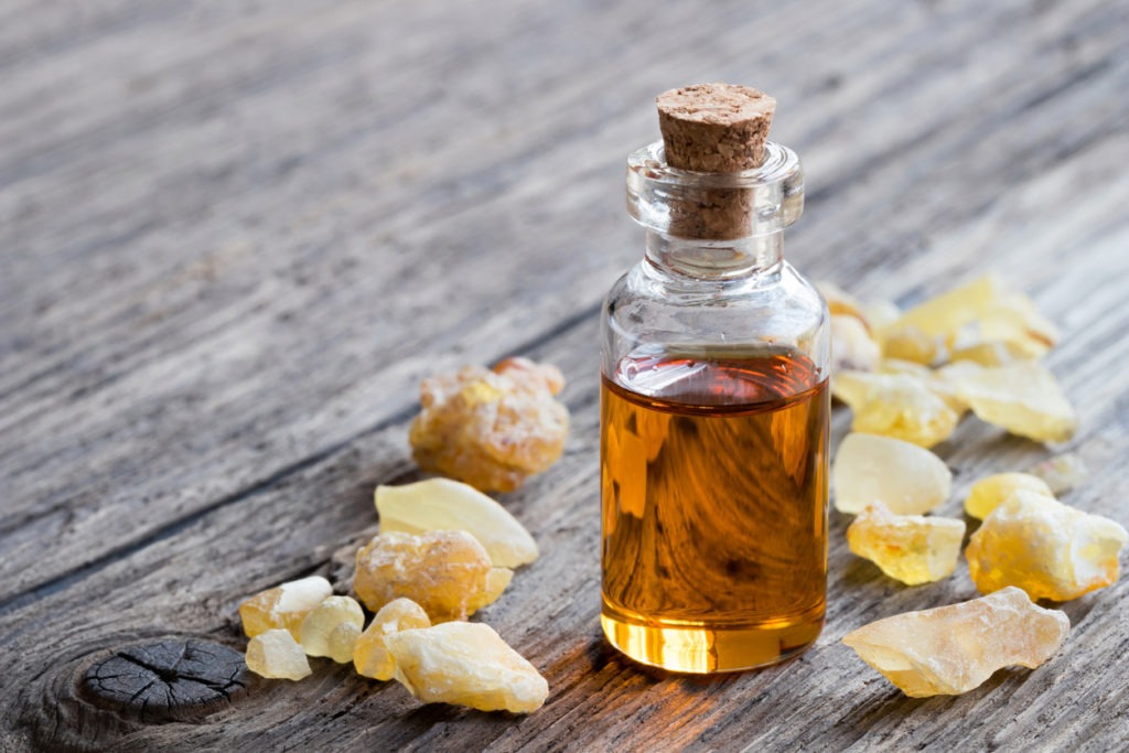 A bottle of frankincense essential oil with frankincense resin
