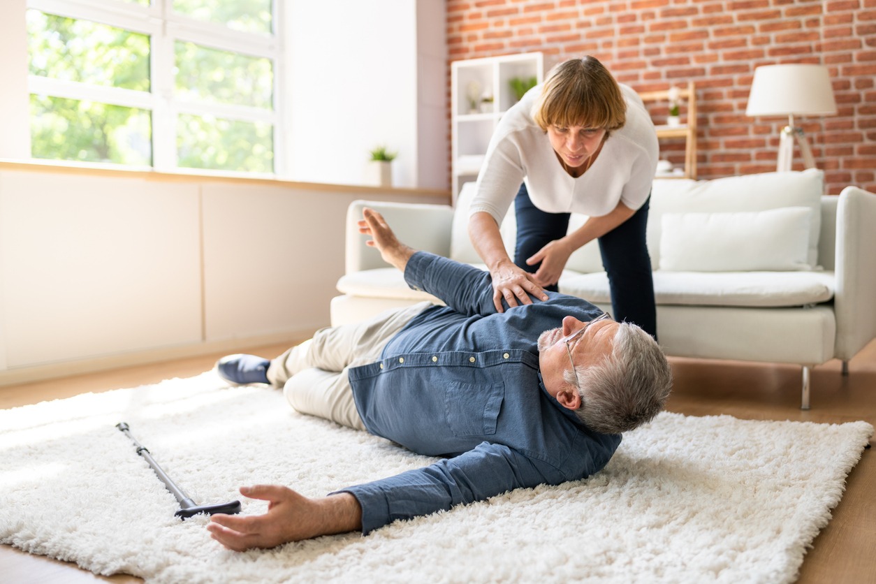 a woman helping an elderly man to get up from the floor