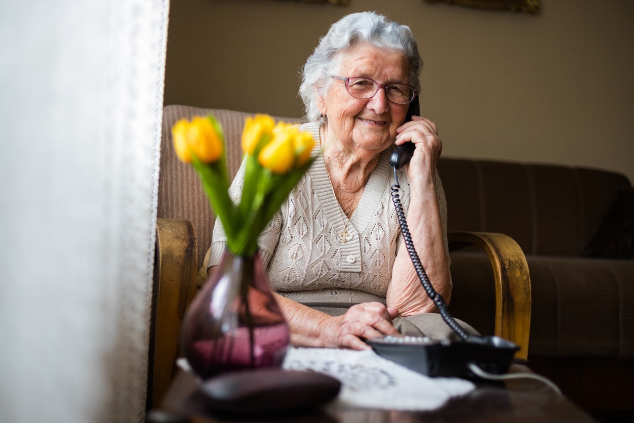 elderly woman using a telephone