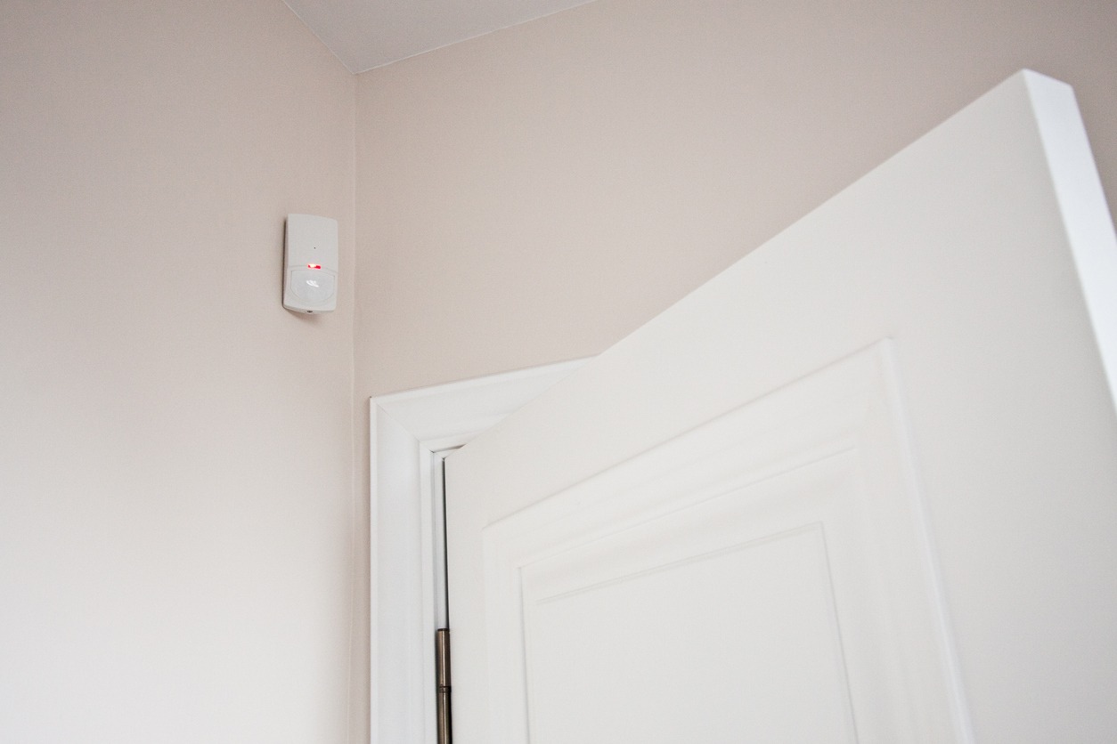 a cordless motion sensor alarm on the wall