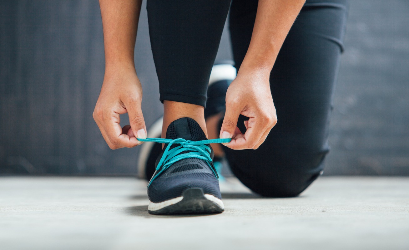 person tying her shoes before running