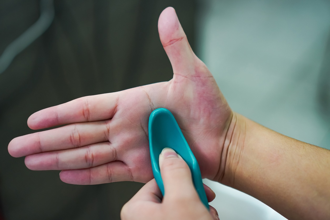 person using a portable hand massager