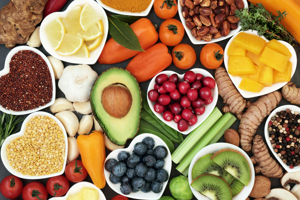 Health food for fitness concept with fresh fruit, vegetables, pulses, herbs, spices, nuts, grains and pulses. High in anthocyanins, antioxidants, smart carbohydrates, omega 3 fatty acids, minerals and vitamins