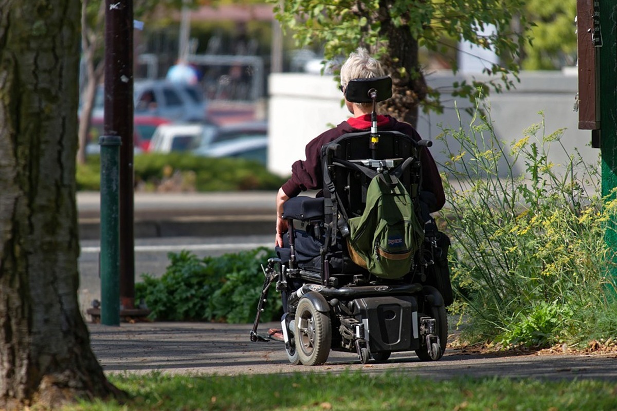 man traveling in a wheelchair with a backpack
