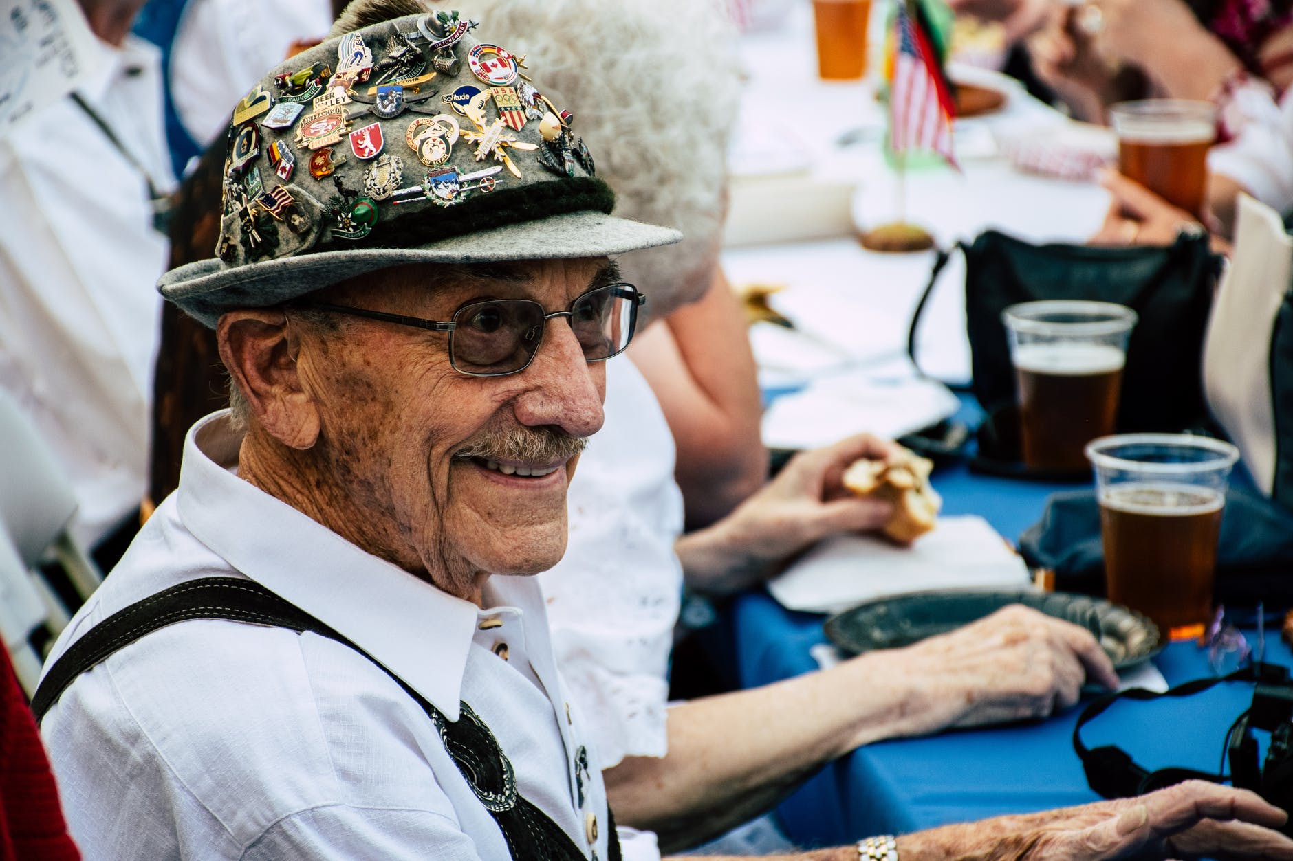 a happy old man sitting near a blue table