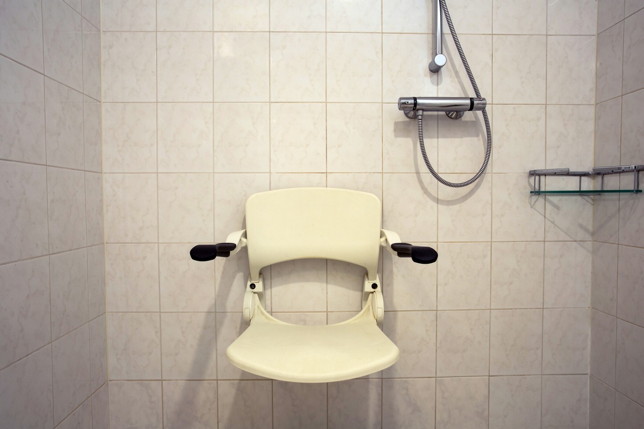 a wall-mounted fold-down shower chair