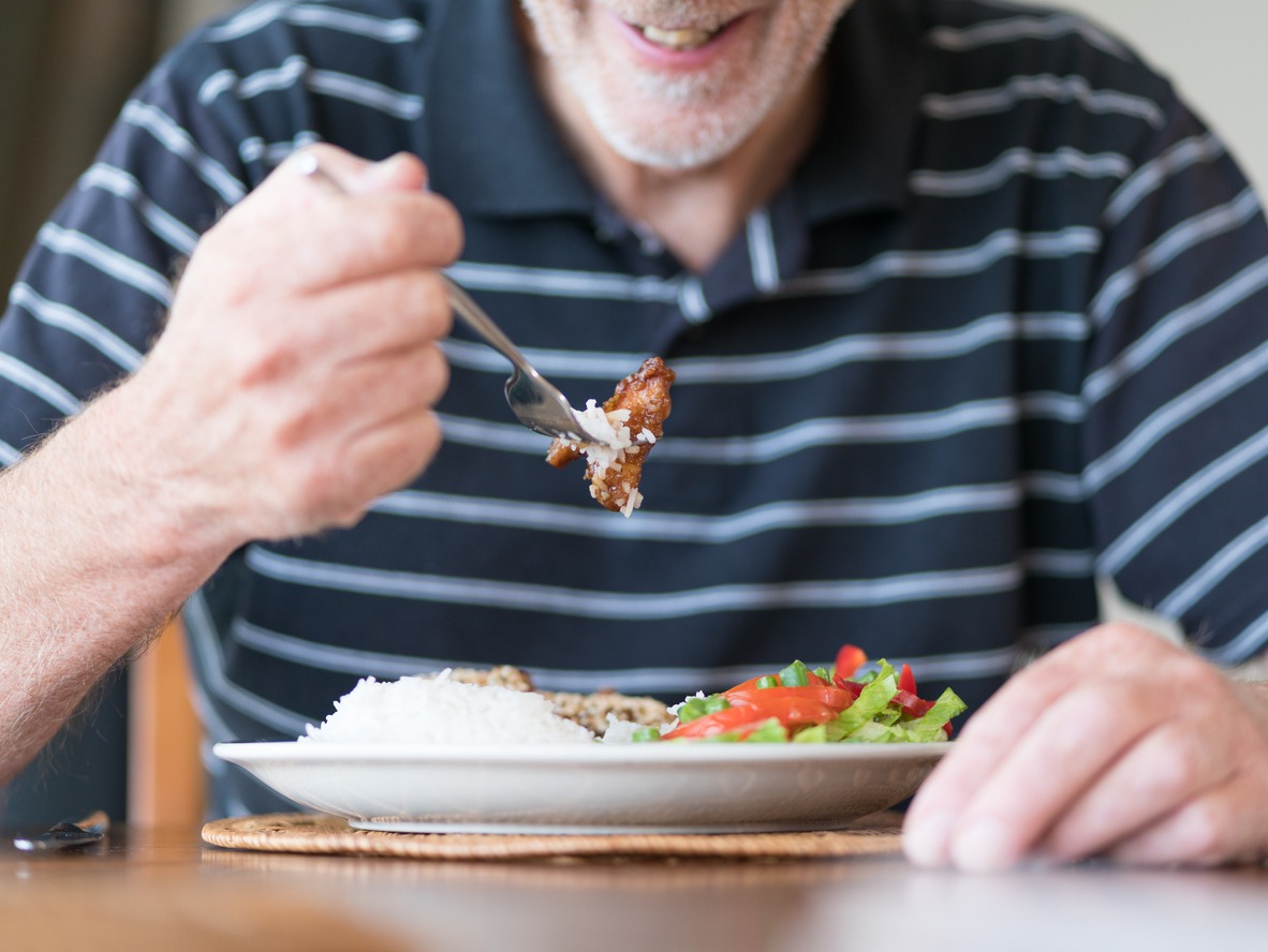 an elderly man enjoying his meal