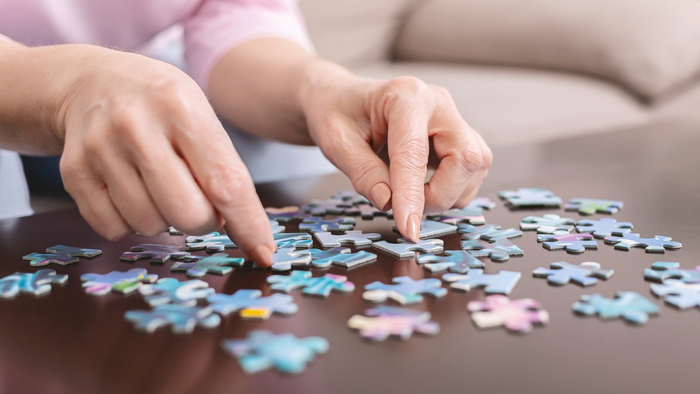elderly person playing with a puzzle pack