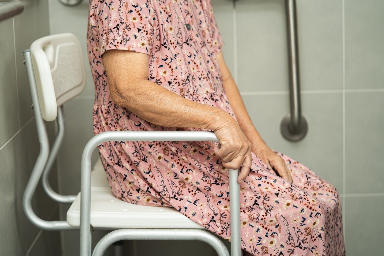 elderly woman sitting on a transfer bench