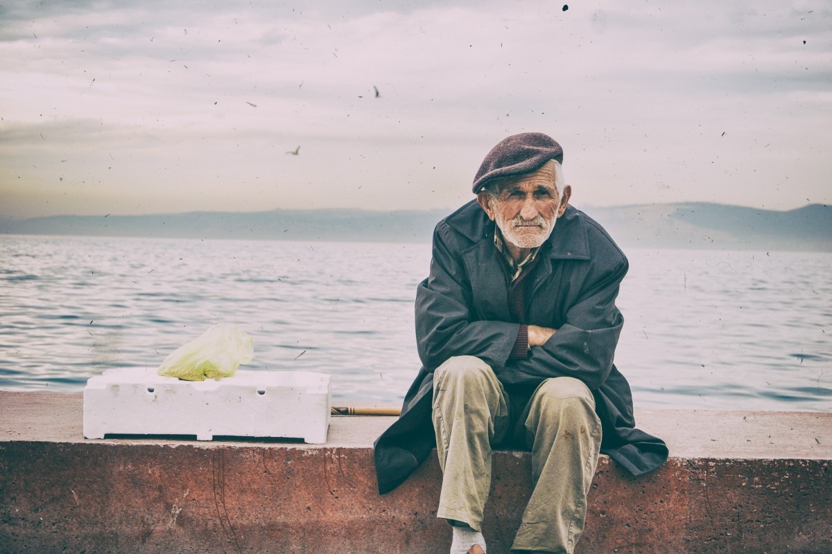 old man sitting near a beach