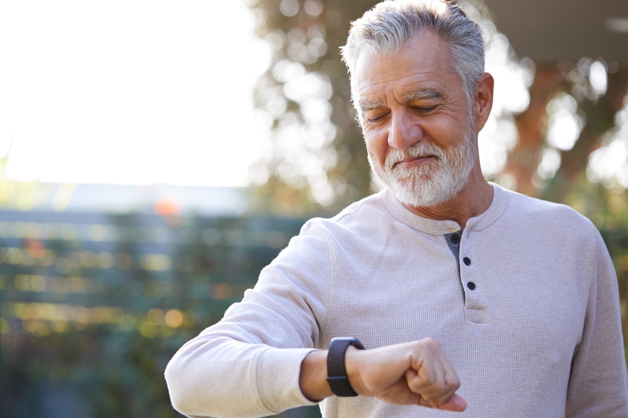 a senior man looking at his smartwatch
