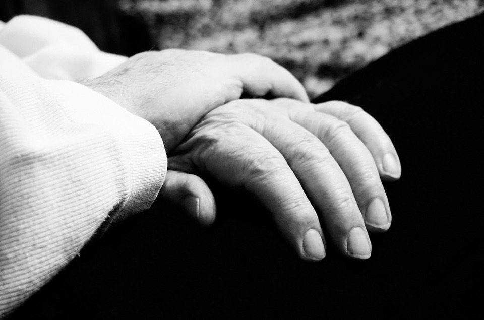 a person holding an older adult’s hand
