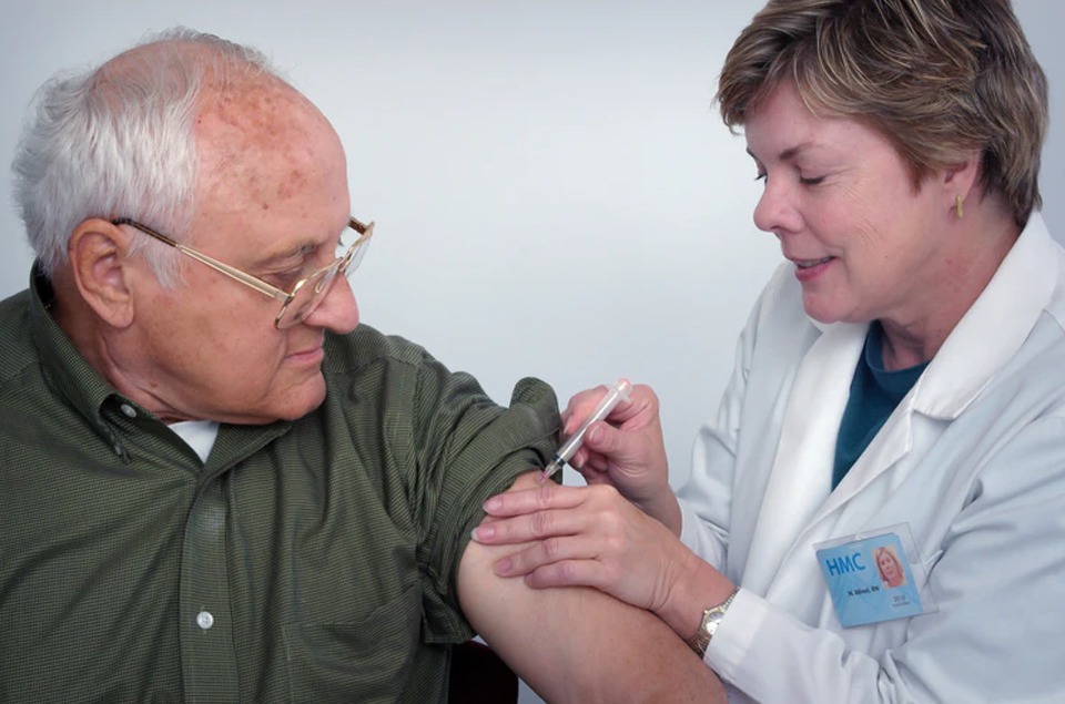 doctor injecting a syringe into an older adult’s arm