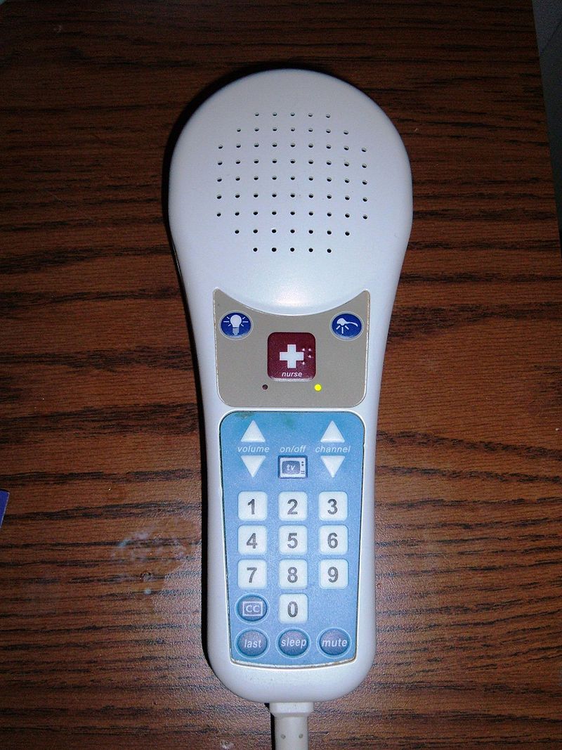 A nurse call button on a pillow speaker with TV controls
