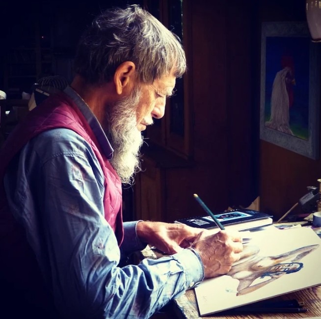 An old man painting on paper