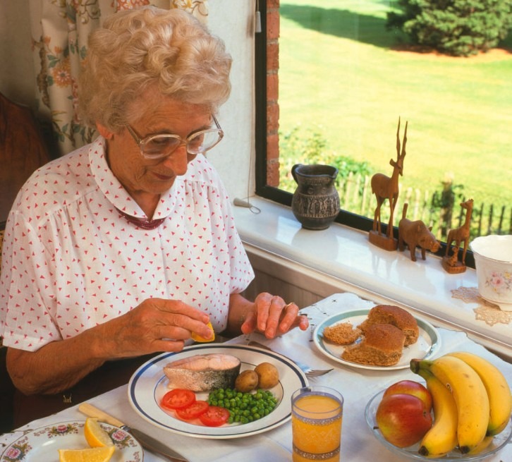 An older woman eating her food