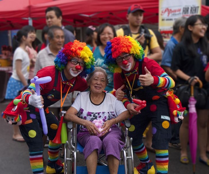 Image of two clowns with an elderly woman.