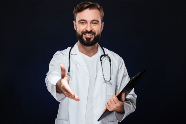 Picture of a happy doctor dressed professionally with his arm extended for a handshake.