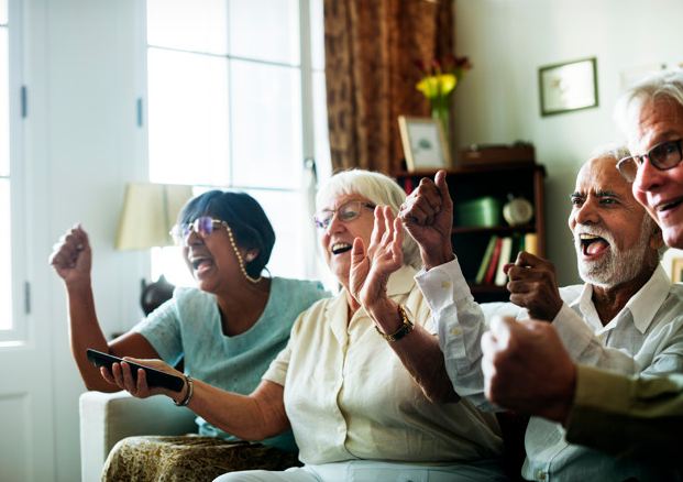 Picture of elderly people watching television together.