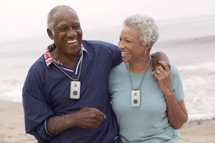 an elderly couple wearing an emergency call system