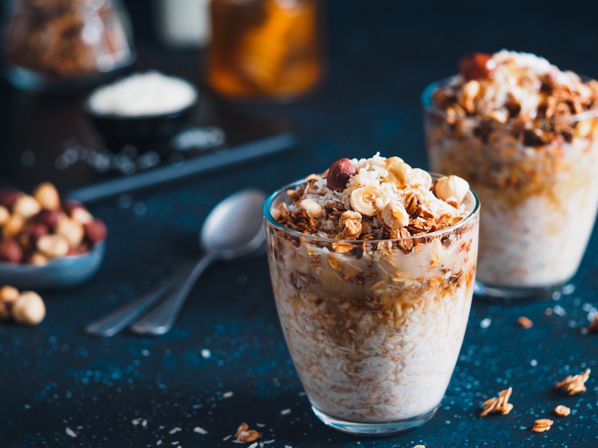 Gingerbread coconut overnight oatmeal served with granola, pecan, and honey. Recipe and idea healthy vegan breakfast - plant-based milk overnight oats with chia and gingerbread spices cinnamon, nutmeg, ginger