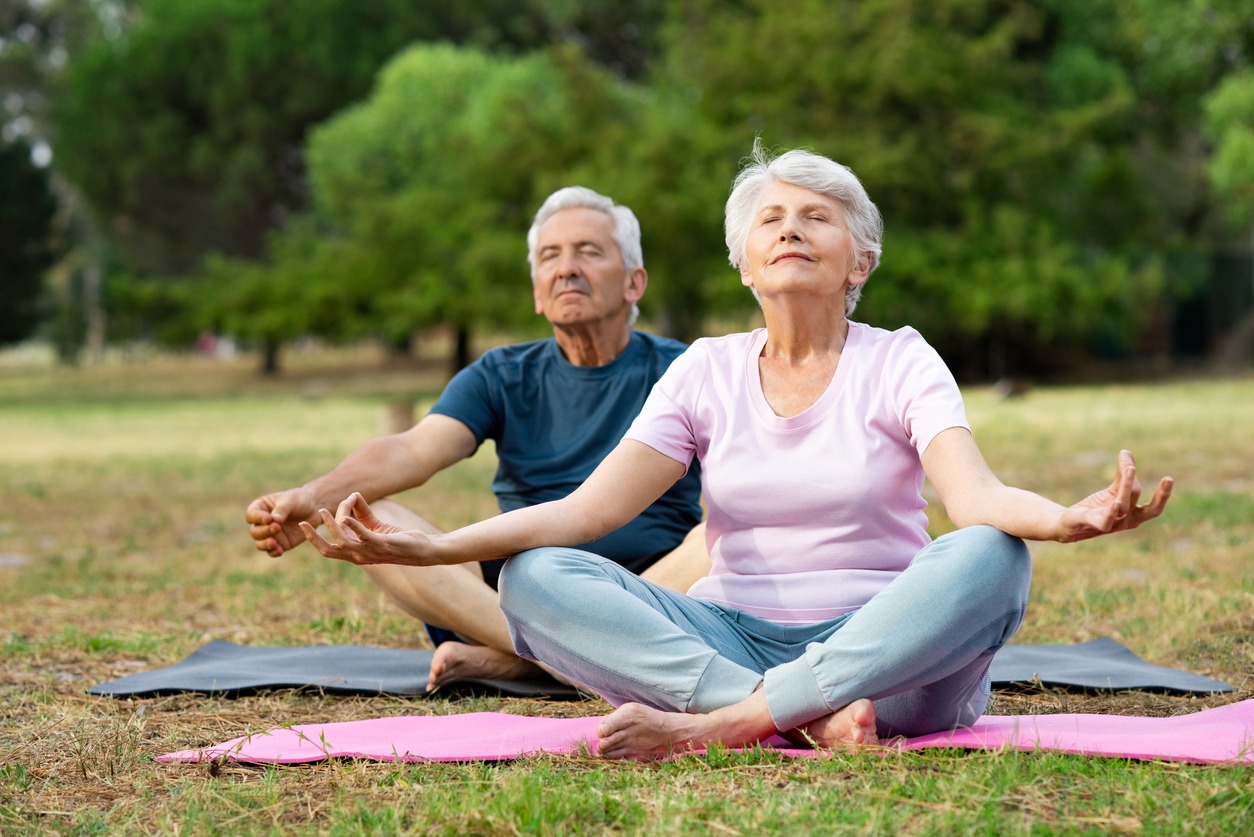 A senior couple doing yoga outdoors