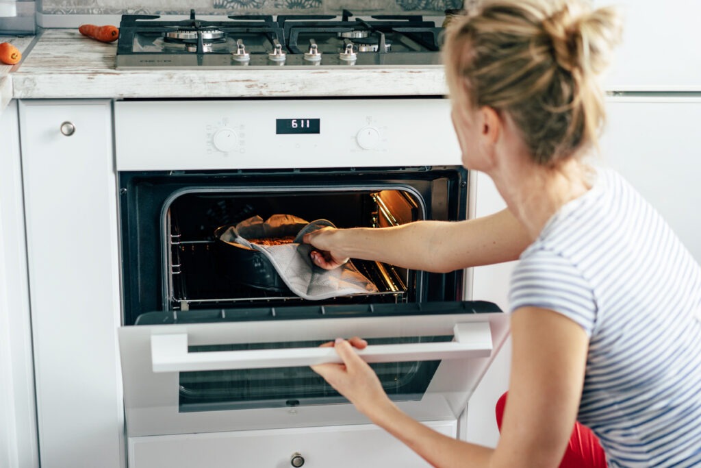 Caucasian woman takes a pie out of the oven. Home cooking flavored pastries. Weekend for the whole family, healthy food