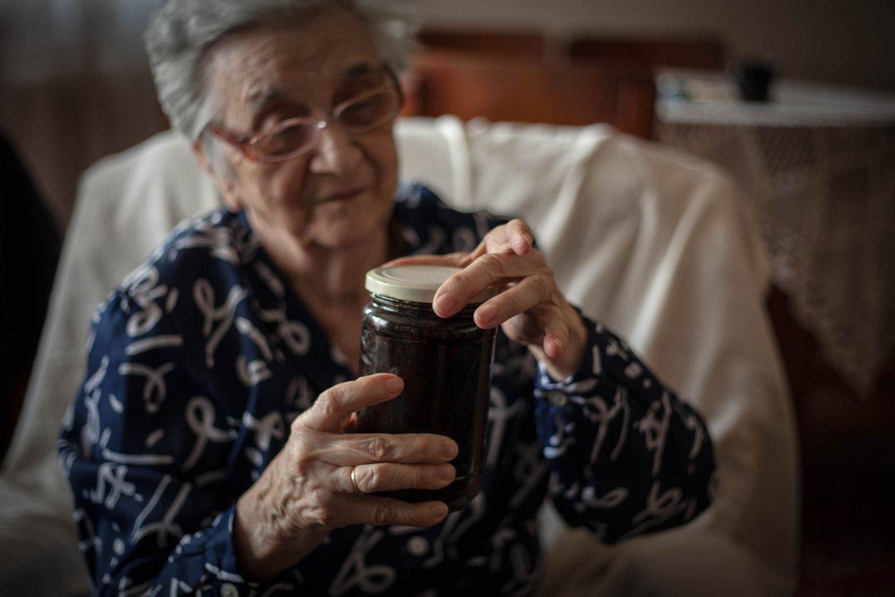 senior woman opening a jar