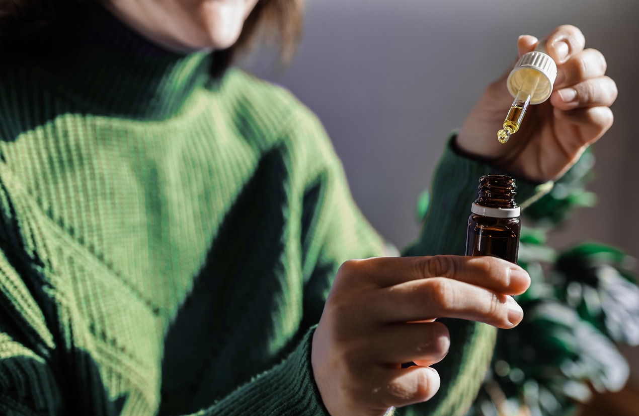 person holding a small bottle of hemp oil