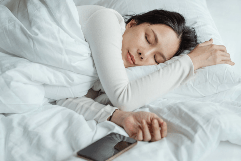 woman-sleeping-in-bed-near-smartphone
