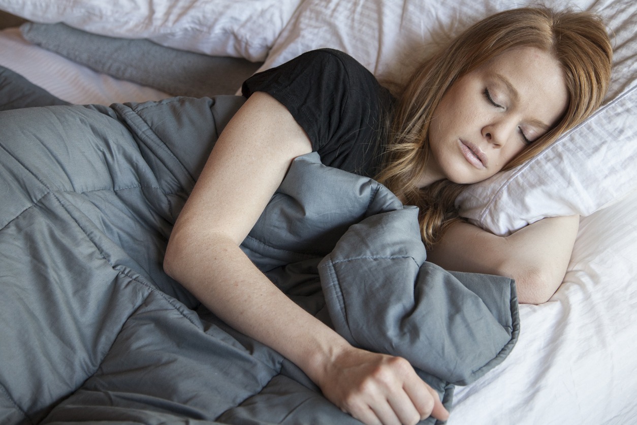 woman sleeping with a weighted blanket