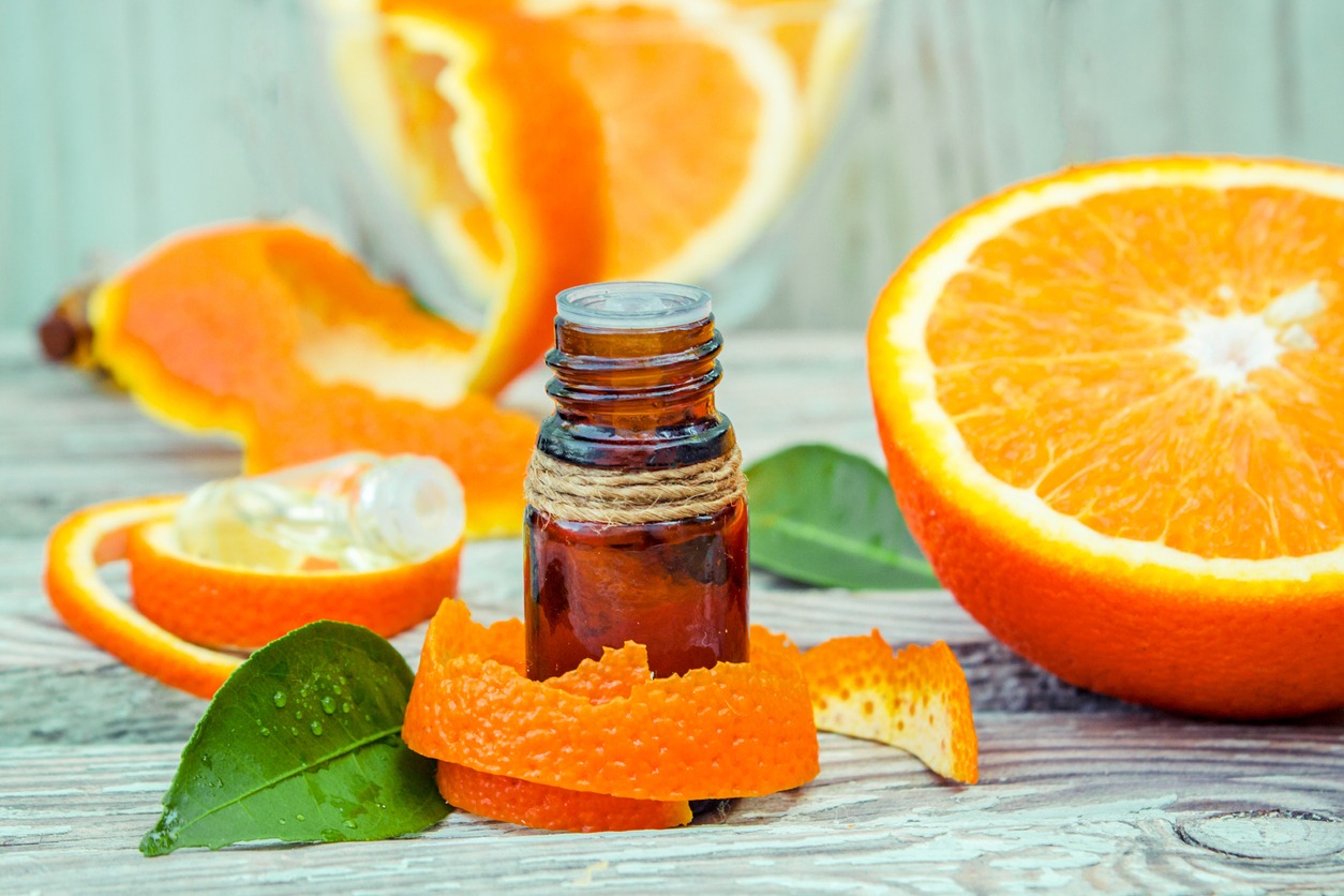 a bottle of orange oil with fresh orange