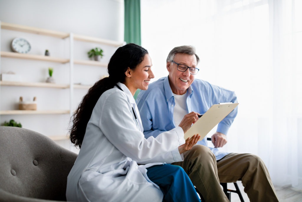 a doctor providing at-home physician care to an older adult