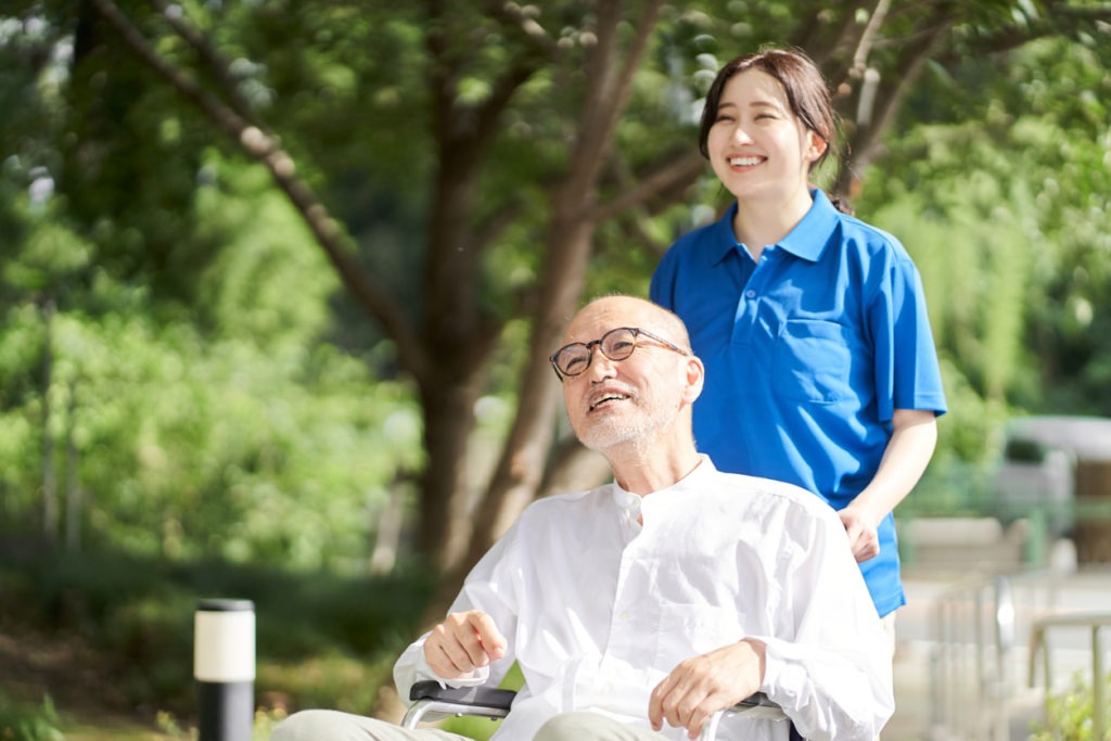 a home health aide supporting the elderly in a wheelchair