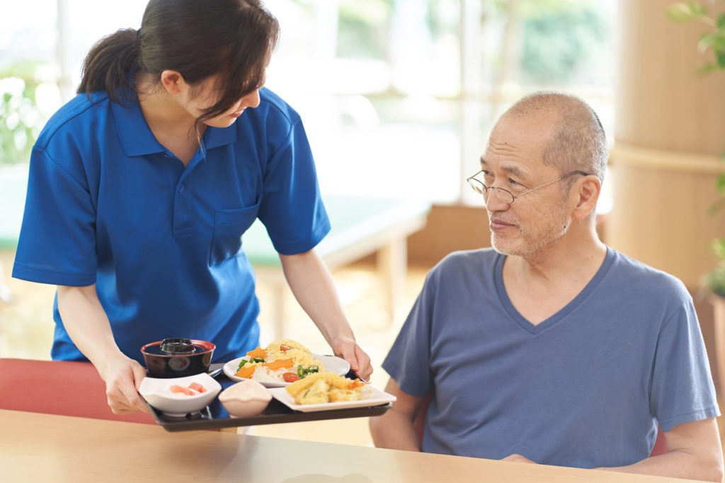 giving meal to an elderly man