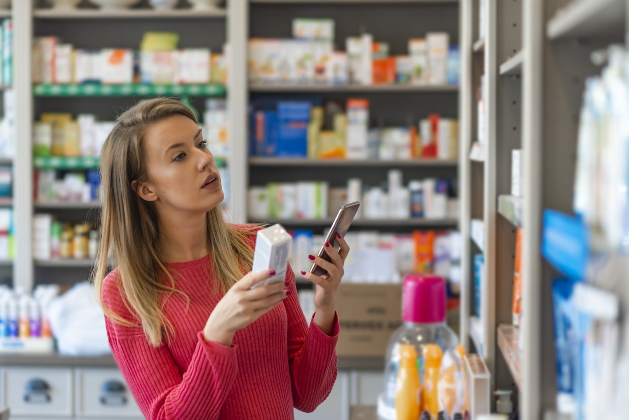 person selecting a product on a pharmacy shelf