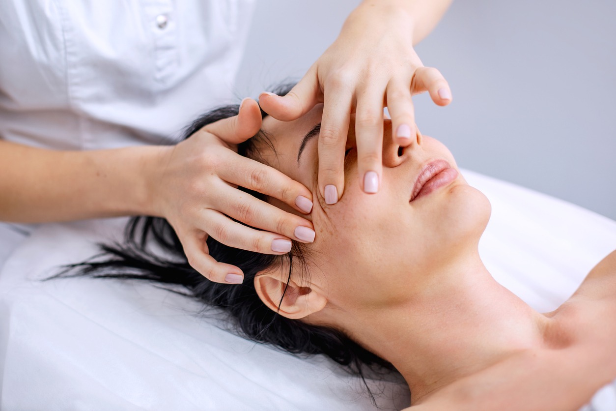 therapist performing a facial massage