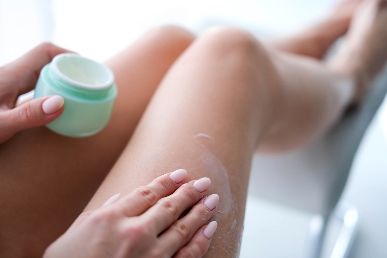woman applying moisturizer on thighs