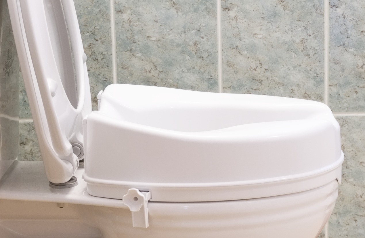 a raised toilet seat attached to the toilet bowl