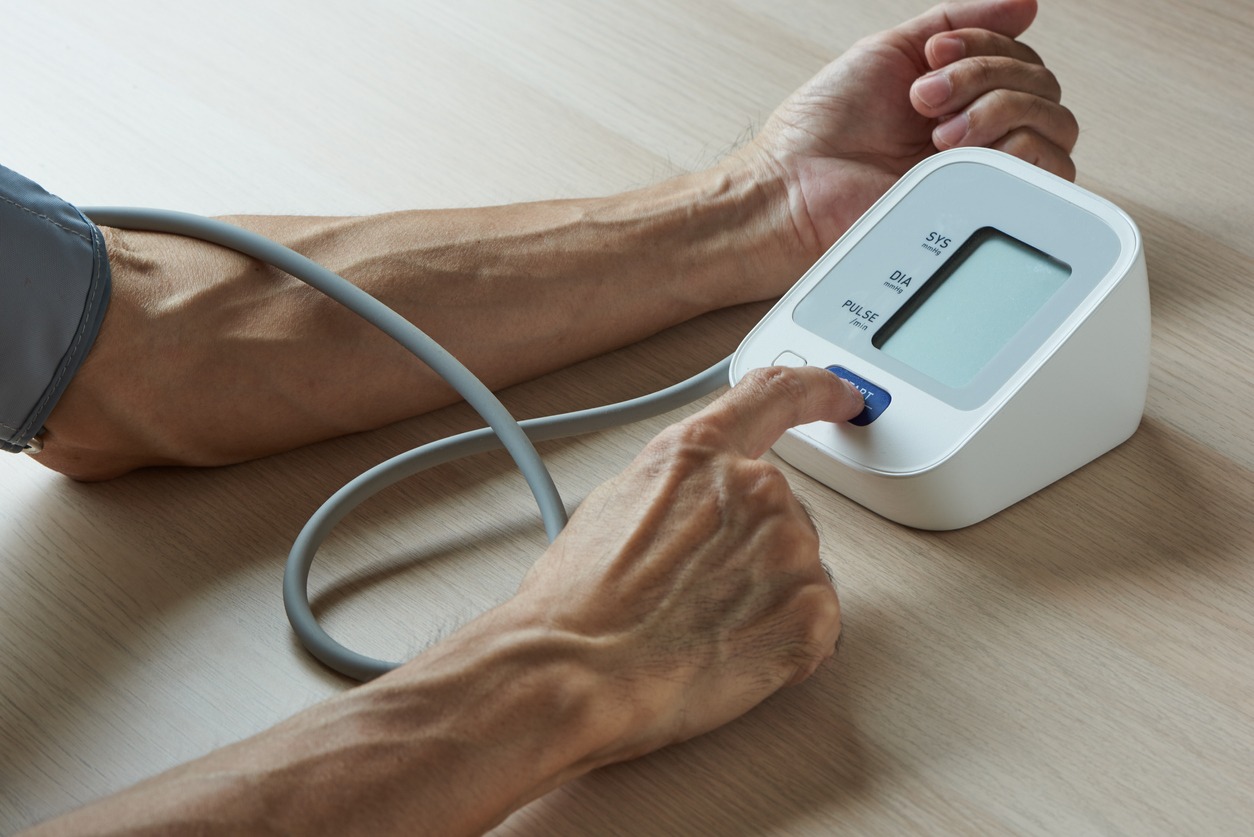 elderly person using a digital blood pressure monitor