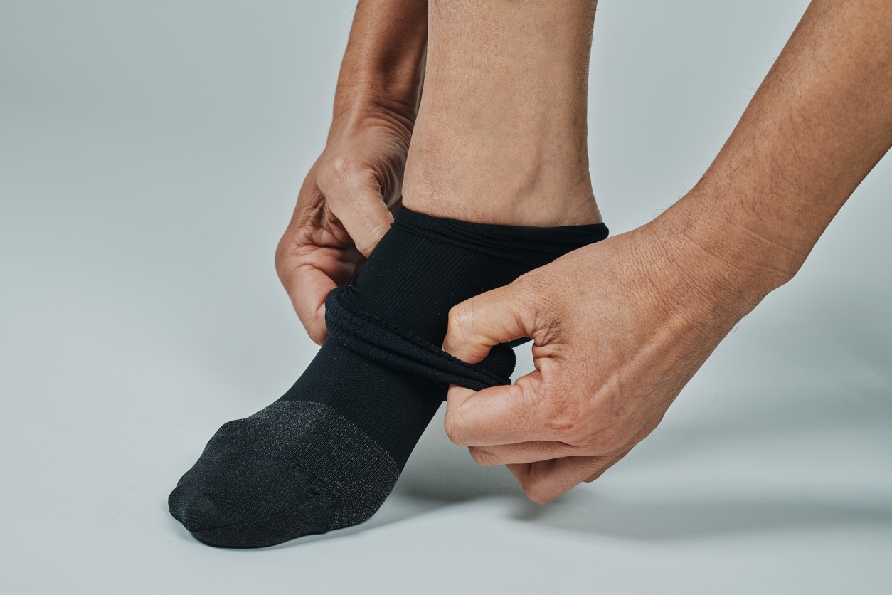 man putting on compression socks on his foot