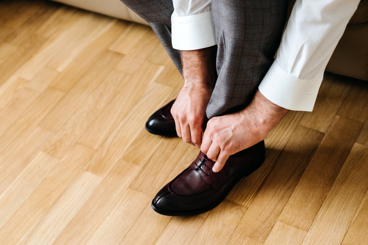 man putting on leather shoes
