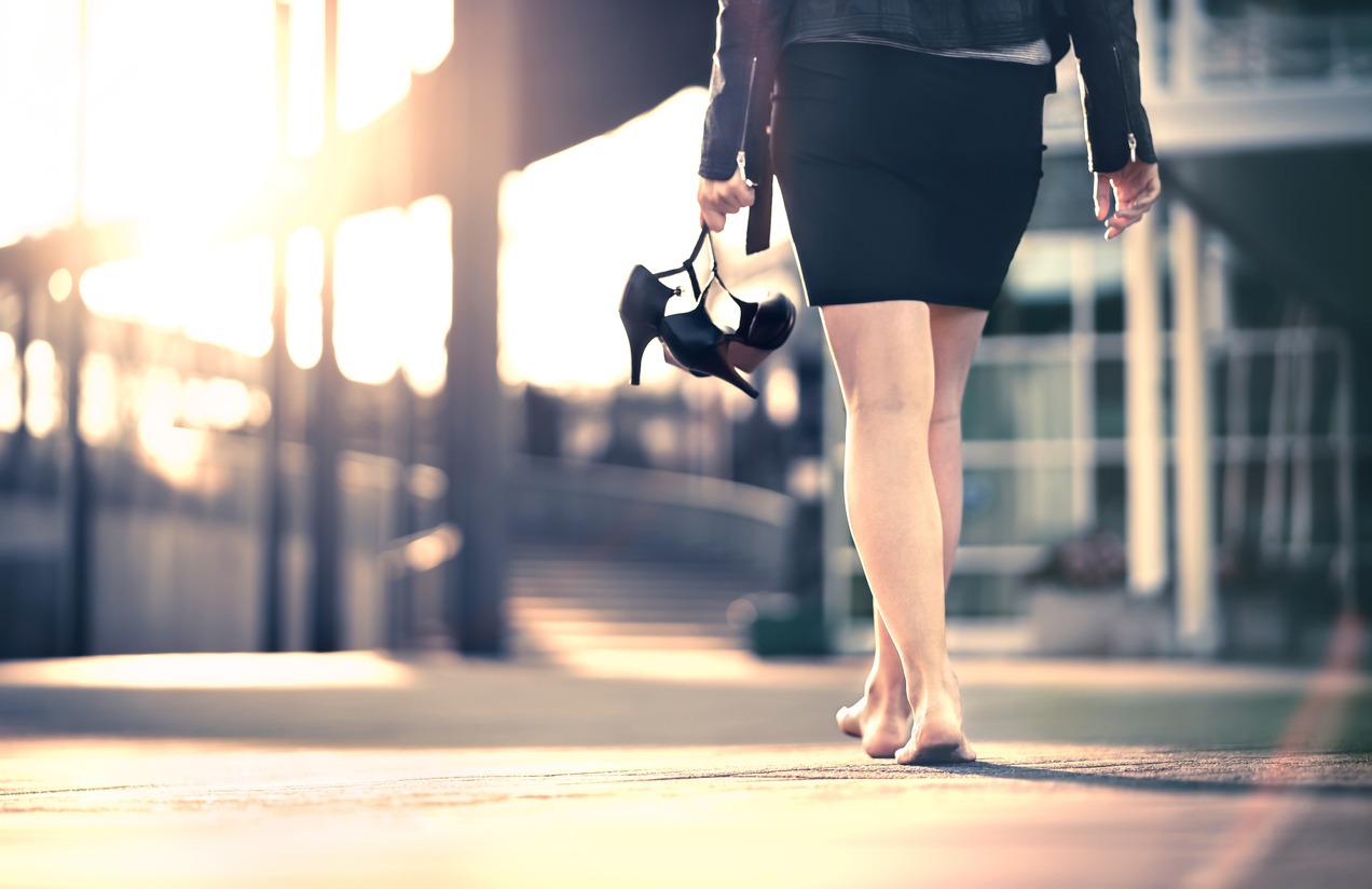 a woman walking while carrying her high heels